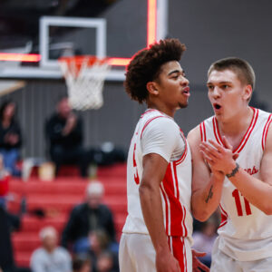 Two basketball players cheer on the court
